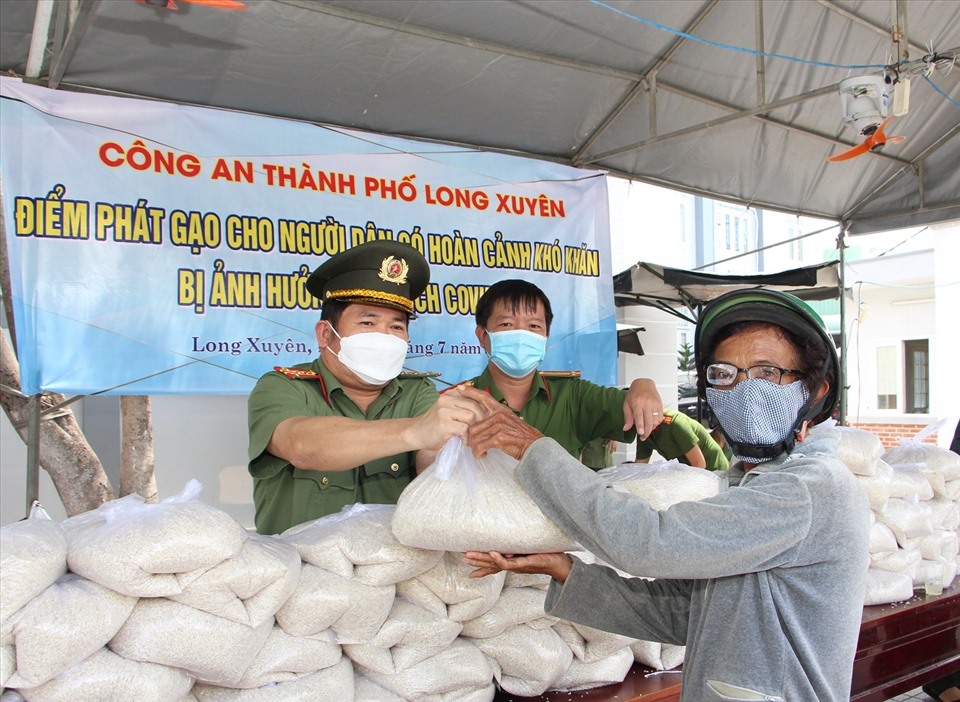 Đại tá Đinh Văn Nơi trực tiếp phát gạo cho người dân có hoàn cảnh khó khăn tại TP. Long Xuyên. Ảnh: PG