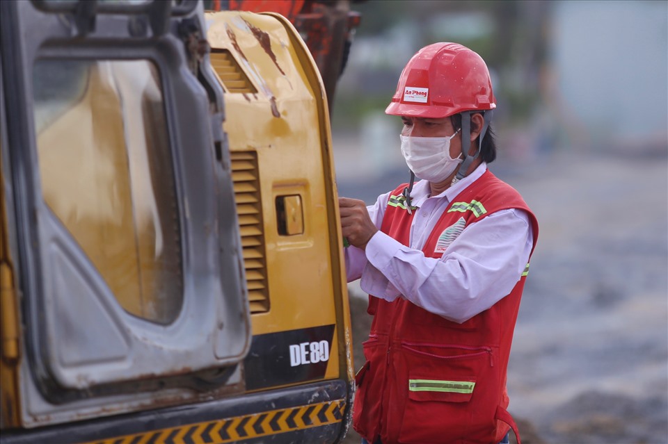 Công nhân Nguyễn Hoàng Tùng đang khắc phục sự cố của chiếc máy xúc.