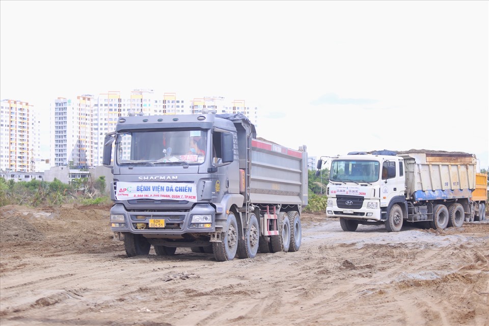 Hàng chục chiếc xe ben chở cát đá nối đuôi nhau ở công trình nằm trên đại lộ Nguyễn Văn Linh.