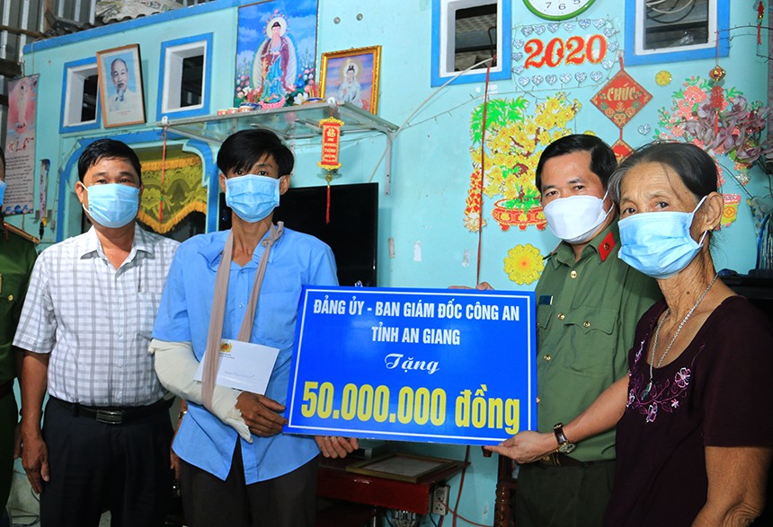 Đại tá Đinh Văn Nơi trao hỗ trợ Nhà Tình thương trị giá 50 triệu đồng cho anh Đạo. Ảnh: CA tỉnh An Giang