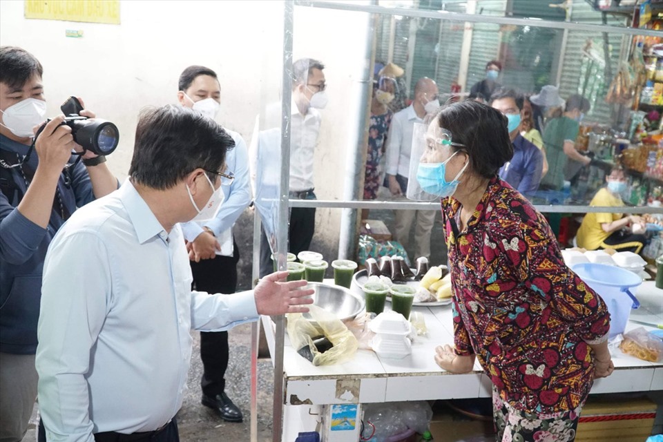 Chủ tịch UBND TPHCM Nguyễn Thành Phong hỏi thăm tình hình buôn bán tại chợ của tiểu thương.  Ảnh: Tam Nguyên