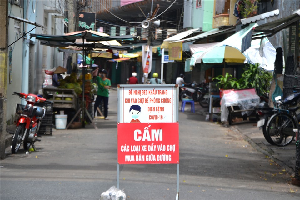 Trước cổng ra- vào chợ truyền thống ở tỉnh An Giang có biển khuyến cáo người đi chợ đảm bảo an toàn với dịch COVID-19. Ảnh: LT