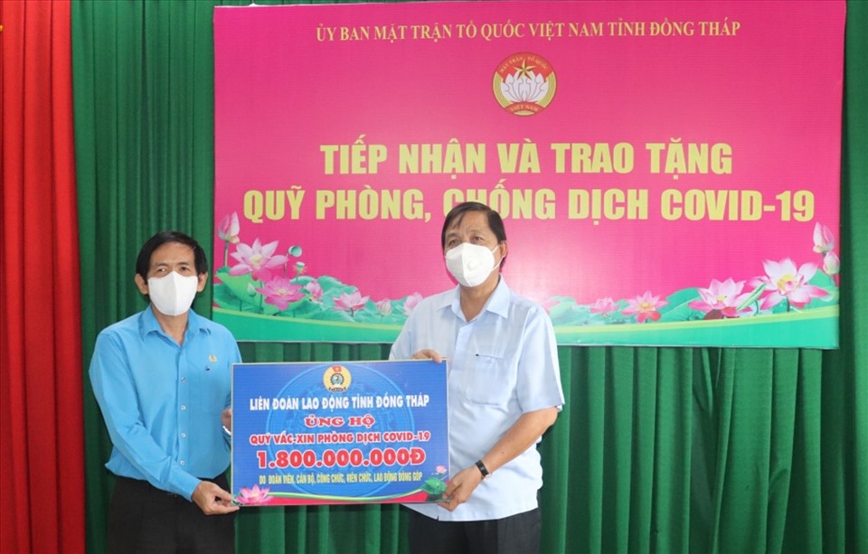 Chủ tịch LĐLĐ tỉnh Đồng Tháp Trần Hoàng Vũ trao bảng tượng trưng số tiền 1,8 tỉ đồng ủng hộ Quỹ vaccine chống dịch COVID-19. Ảnh LƯU HÙNG