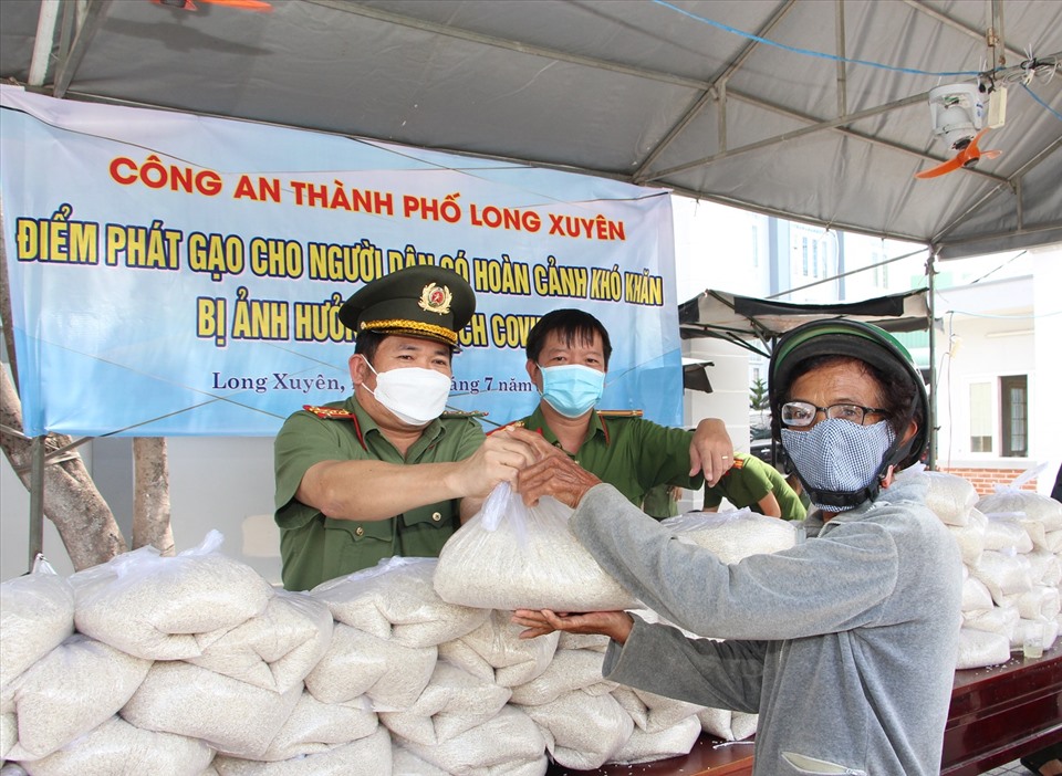 Đại tá Đinh Văn Nơi, Giám đốc Công an tỉnh An Giang, trực tiếp hỗ trợ gạo cho người dân bị ảnh hưởng dịch COVID-19. Ảnh: NT