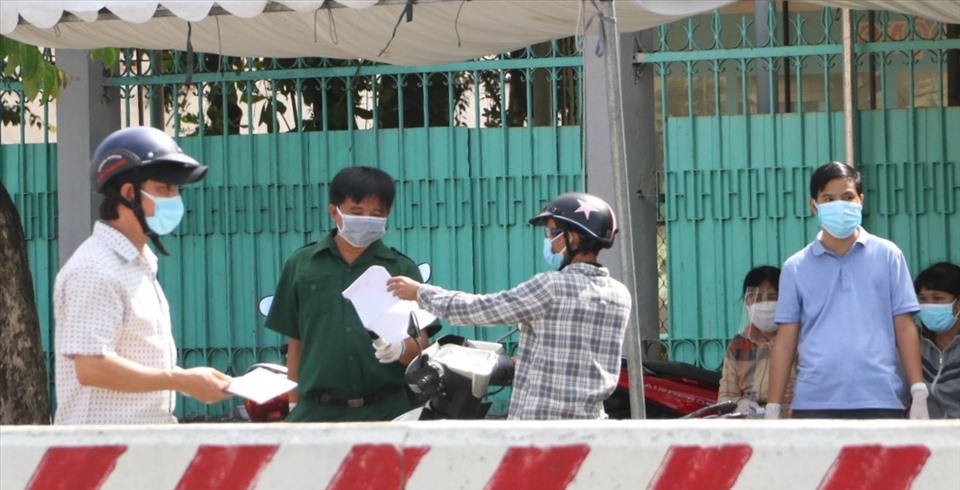 Lực lượng chức năng kiểm tra giấy xét nghiệm âm tính với COVID-19 của người dân di chuyển từ thành phố Thủ Dầu Một qua thị xã Bến Cát. Ảnh: Đình Trọng