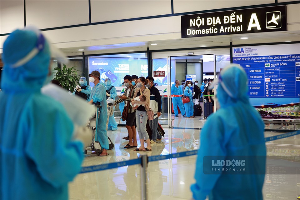 Các nhân viên của Sở Y tế Hà Nội kiểm đếm danh sách hành khách từ TP.Hồ Chí Minh về Hà Nội tối 22.7 tại sân bay Nội Bài.