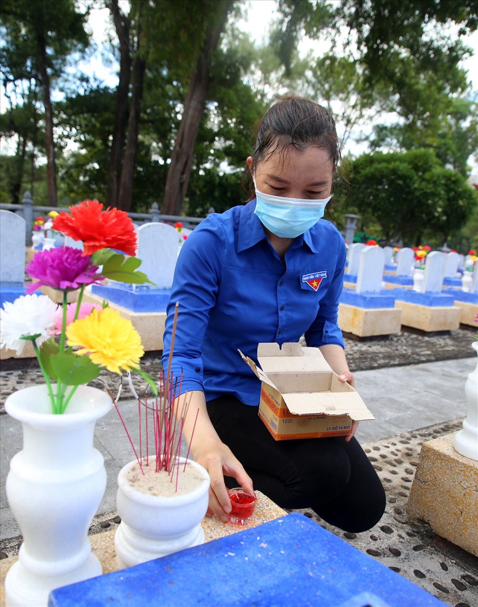 Các đoàn viên thanh niên đến chăm sóc từng phần mộ ở Nghĩa trang liệt sĩ Quốc gia Trường Sơn, đặt lên đó các ngọn nến.