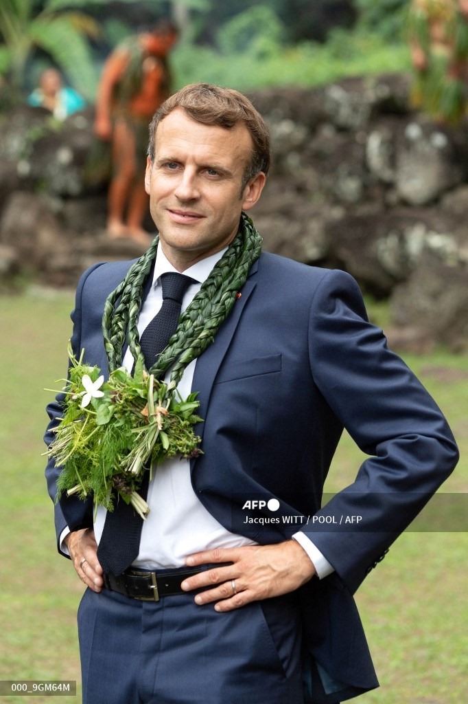 Tổng thống Pháp dự một nghi lễ nhảy ở địa điểm khảo cổ Upeke, trên đảo Hiva Oa, hòn đảo lớn thứ hai của đảo Marquesas, thuộc Polynesia thuộc Pháp hôm 26.7. Ông cũng đeo một vòng hoa đeo cổ khác màu xanh lá. Ảnh: AFP