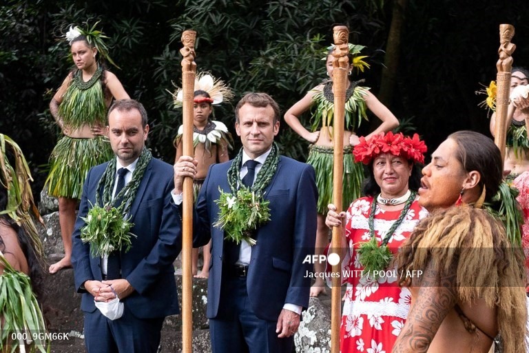 Tổng thống Pháp dự một nghi lễ nhảy ở địa điểm khảo cổ Upeke, trên đảo Hiva Oa, hòn đảo lớn thứ hai của đảo Marquesas, thuộc Polynesia thuộc Pháp hôm 26.7. Ông cũng đeo một vòng hoa đeo cổ khác màu xanh lá. Ảnh: AFP