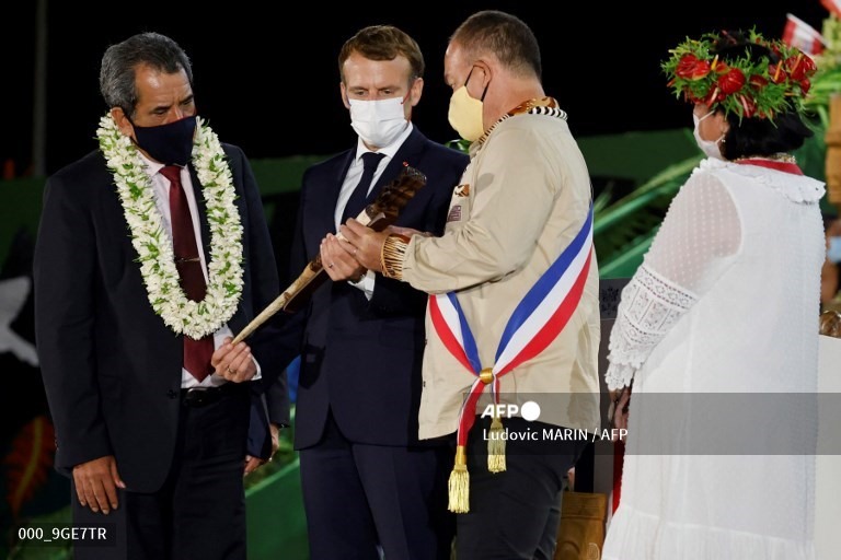 Tổng thống Pháp Emmanuel Macron được các đại diện địa phương tặng quà trong buổi lễ chào mừng và biểu diễn văn hóa dân gian khi đến thăm Atuona ở Hiva Oa - hòn đảo lớn thứ hai của quần đảo Marquesas, Polynesia thuộc Pháp ngày 25.7. Ảnh: AFP