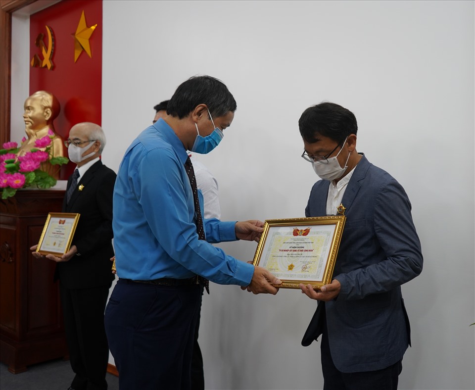 Ông Hoàng Đình Long - Phó Chủ tịch LĐLĐ TP.Hải Phòng trao kỉ niệm chương cho các cá nhân. Ảnh Mai Dung