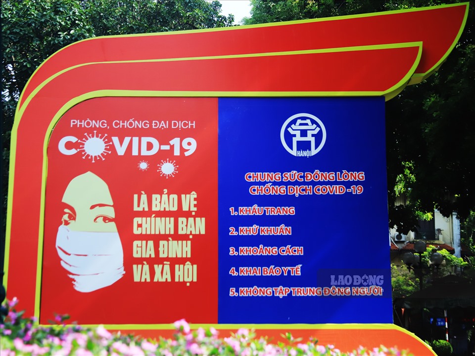 Một tấm pa nô lớn mang thông điệp “Phòng chống đại dịch Covid-19 là bảo vệ chính bạn, gia đình và xã hội” được đặt tại khu vực hồ Hoàn Kiếm.