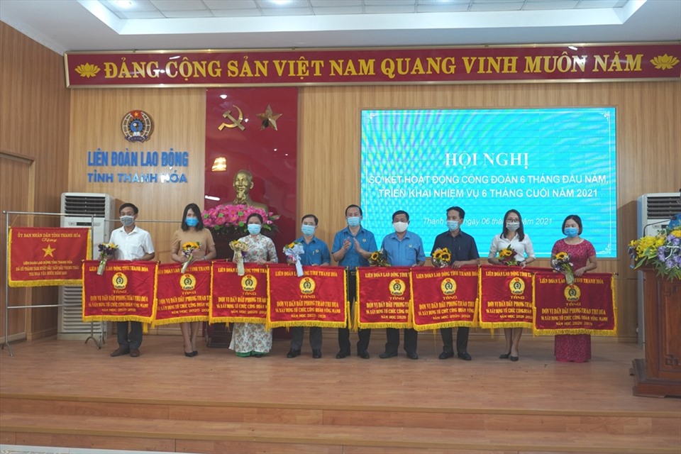 Đại diện lãnh đạo LĐLĐ tỉnh Thanh Hóa trao cờ thi đua cho các đơn vị có thành tích xuất sắc trong 6 tháng đầu năm. Ảnh: Q.D