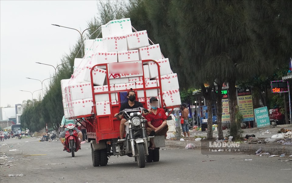 Từng thùng hàng được xếp lên xe để vận chuyển ra ngoài chợ.