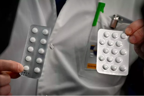 Một nhân viên y tế cầm các vỉ chloroquine và hydroxychloroquine - hai loại thuốc đang được thử nghiệm để điều trị COVID-19. Ảnh: AFP/LTATimes