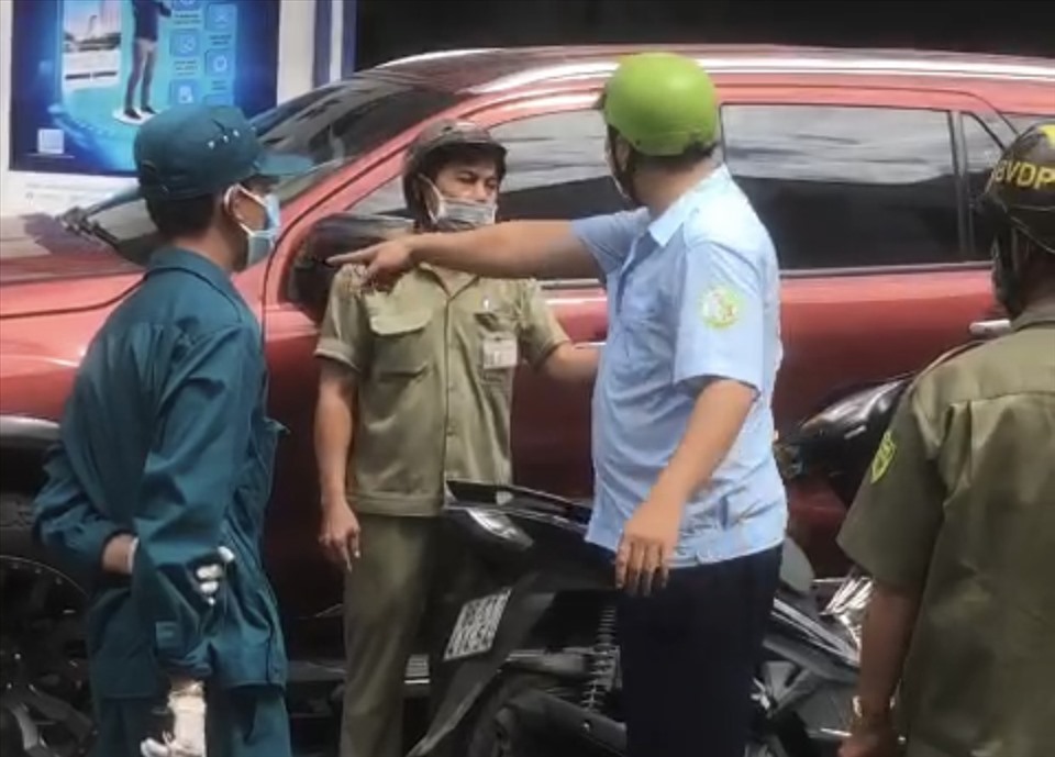 Ông D (áo xanh dương, nón bảo hiểm xanh lá cây) khi bị chặn dừng. Ảnh cắt từ clip