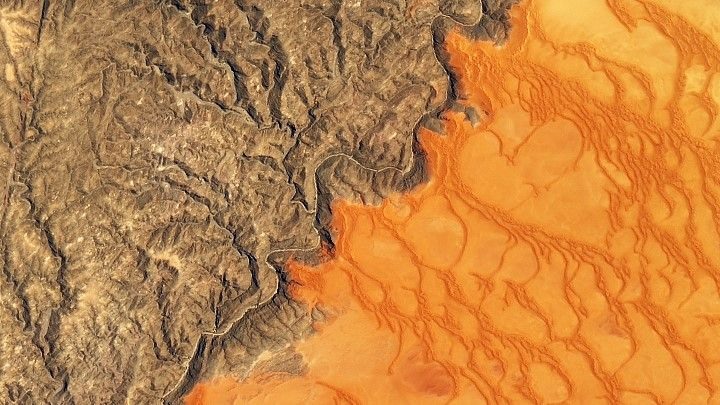 Theo Đài quan sát Trái đất, bức ảnh này được vệ tinh Landsat 8 chụp ngày 13.11.2019. Ảnh cho thấy sự tương phản màu sắc nổi bật giữa biển cát Namib -  sa mạc ven biển duy nhất trên thế giới, rộng hơn 26.000 km vuông và những ngọn núi đá ở Công viên Namib -Naukluft thuộc Namibia. Cát có màu đỏ cam do có oxit sắt. Sông Kuiseb ngăn cát lấn vào núi. Ảnh: NASA