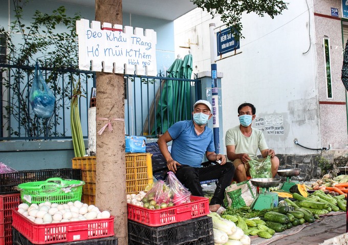 Anh Minh Râu trong môti buổi bán rau (bên trái). Ảnh: MCV.