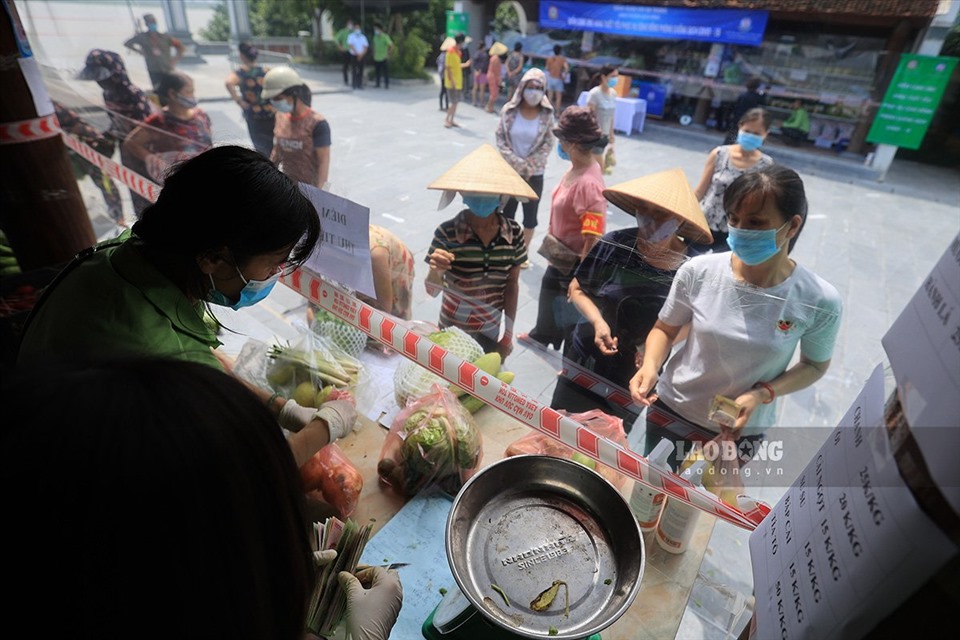 Người dân phường Bạch Đằng (Hai Bà Trưng) mua bán nhu yếu phẩm tại điểm cung ứng hàng thiết yếu phục vụ cộng đồng phòng chống dịch COVID-19 tại địa chỉ 680 Bạch Đằng.
