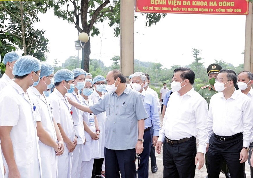 Chủ tịch nước Nguyễn Xuân Phúc động viên các nhân viên ý tế làm việc tại cơ sở thu dung, điều trị bệnh nhân mắc COVID-19 do Bệnh viện Đa khoa Hà Đông điều hành. Ảnh: Thống Nhất