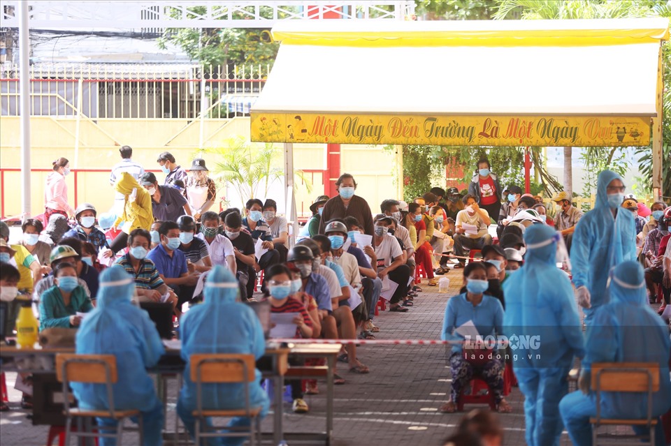 Ghi nhận tại điểm tiêm trường tiểu học Bình Hưng (xã Bình Hưng, huyện Bình Chánh), đông người dân đã xếp hàng ngay ngắn chờ đến lượt đăng ký tiêm vaccine.