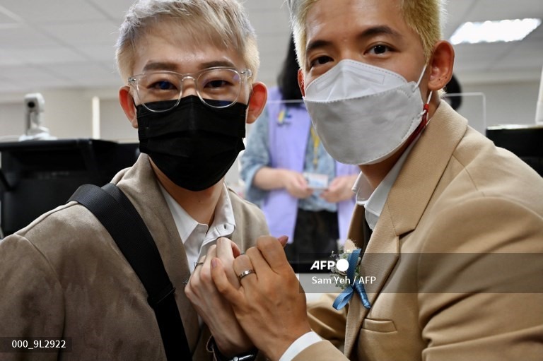 Cặp đôi đồng giới Ting Tse-yen ở Đài Loan (Trung Quốc) và Leong Chin-fai từ Macau chụp ảnh khoe nhẫn cưới trong một cuộc họp báo ở Đài Bắc ngày 13.8. Ảnh: AFP