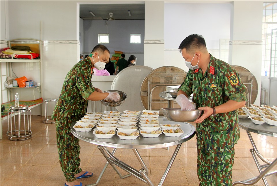 Các cán bộ chiến sỹ Ban Chỉ huy Quân sự huyện Đắk R'lấp chuẩn bị bữa cơm cho người dân đang cách ly. Ảnh: Phan Tuấn