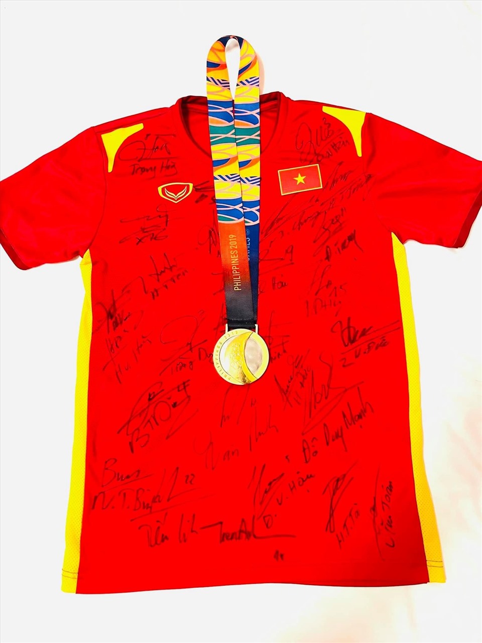 Tấm Huy chương vàng SEA Games và chiếc áo thi đấu tại vòng loại thứ 2 World Cup 2022 được Trọng Hoàng bán đấu giá làm thiện nguyện. Ảnh: FBNV