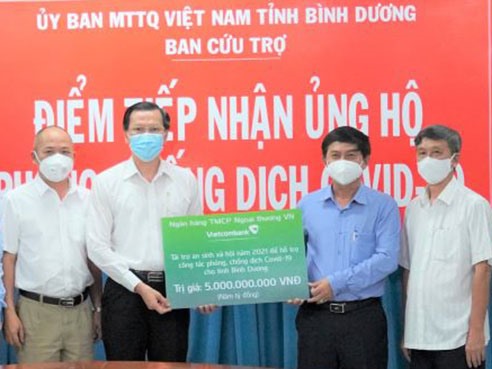 Đại diện Vietcombank trao số tiền tài trợ 5 tỉ đồng cho tỉnh Bình Dương. Ảnh: N.H