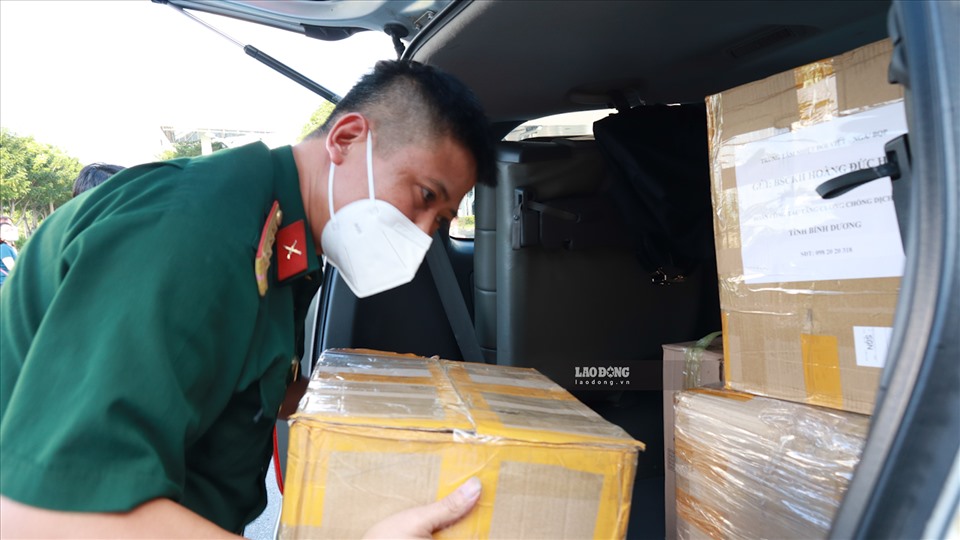 Kỹ thuật viên đang sắp xếp vật tư y tế lên xe để về thị xã Tân Uyên, tỉnh Bình Dương. Ảnh: Nguyễn Ly