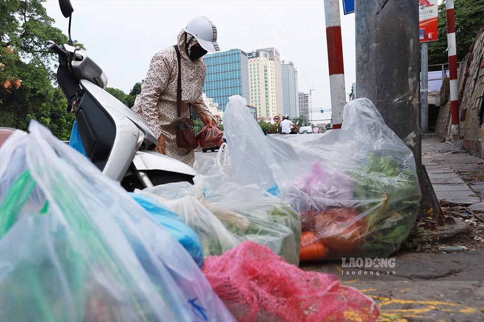 Nhiều gia đình không có người thân ở ngoài vùng phong toả, nên nhờ bạn bè, người quen mua giúp. Ảnh: Chị Nguyễn Hồng Dương đi chợ giúp cho 4 gia đình trong khu cách ly. Để nhớ đủ số lượng, chủng loại mỗi gia đình yêu cầu, chị Dương phải ghi ra sổ và chia sẵn từng túi to cho từng gia đình.