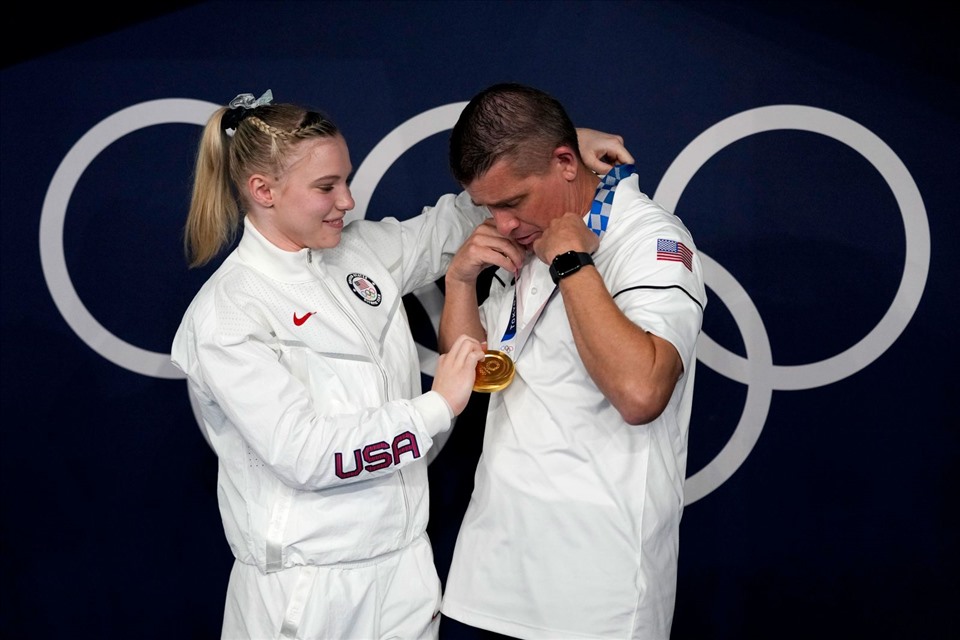 Jade Carey, vận động viên thể dục dụng cụ người Mỹ đã giành huy chương Vàng trong bài tập trên sàn, tự tay đeo huy chương danh giá của mình lên cổ cha và huấn luyện viên Brian, vào ngày 2 tháng 8. Ảnh: CNN