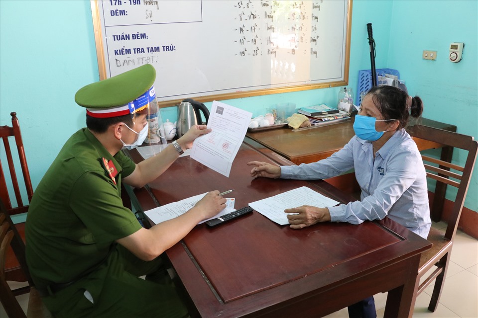 Lực lượng chức năng lập biên bản xử lý đối với Nguyễn Thị Hương về hành vi mượn giấy chứng nhận tiêm vaccine phòng COVID-19 của người khác để qua chốt kiểm dịch. Ảnh: NT