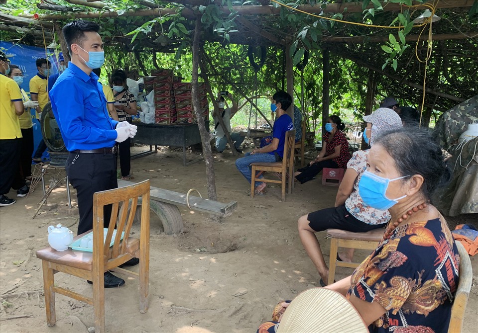 Anh Lý Duy Xuân, Phó Bí thư Thành đoàn Hà Nội (áo xanh) trực tiếp tới tặng quà và động viên người dân đang sinh sống ở xóm Phao. Ảnh: V.Đ