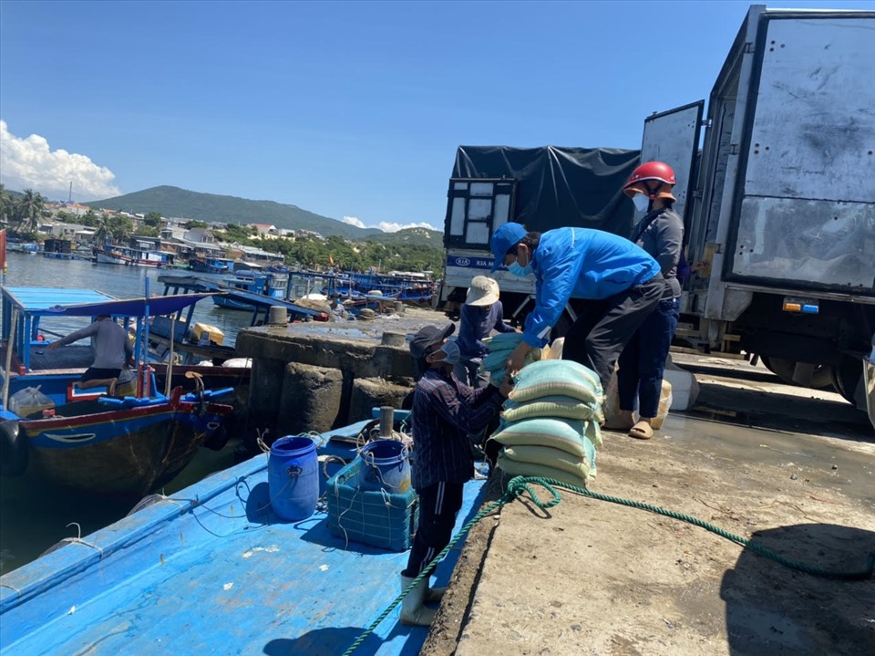 Cán bộ công đoàn huyện Vạn Ninh chuyển nhu yếu phẩm lên tàu đưa ra đảo tiếp sức cho công nhân. Ảnh: Thanh Loan