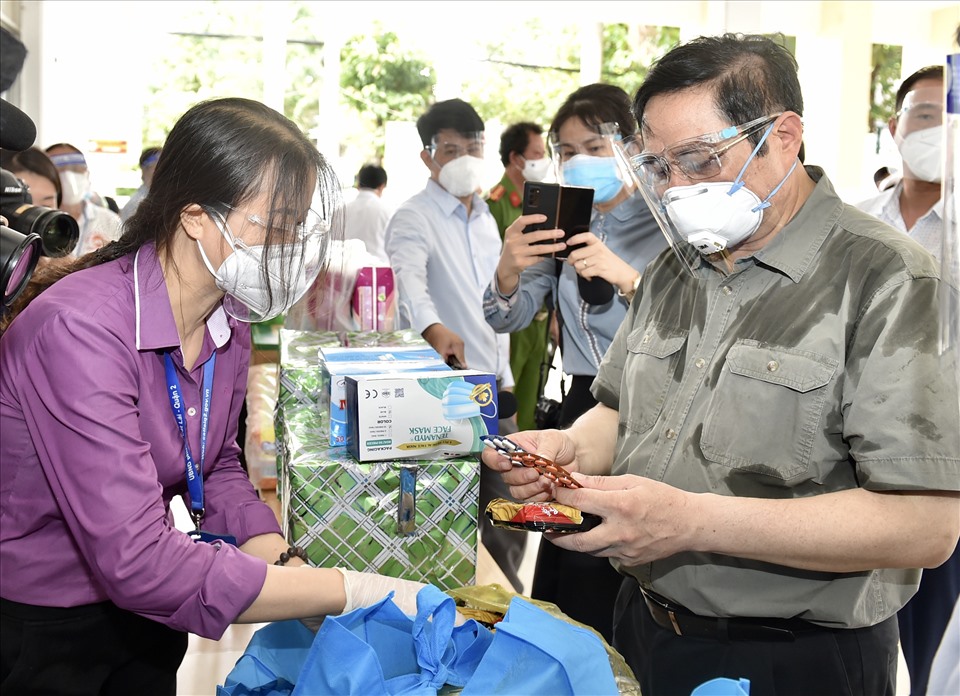 Thủ tướng xem các loại nhu yếu phẩm, thuốc men... trong túi an sinh sẽ được cung cấp cho người dân. Ảnh: VGP/Nhật Bắc