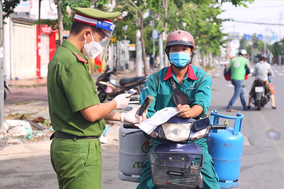 Cán bộ kiểm tra mã QR của người đi đường tại chốt đường Phạm Hùng (giáp ranh Quận 8 và huyện Bình Chánh).