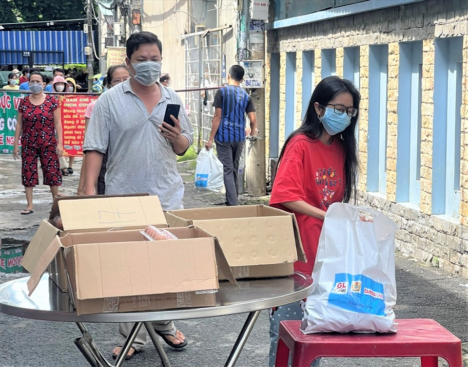 Công nhân, người lao động các khu nhà trọ trên địa bàn Quận Tân Phú xếp hàng bảo đảm giãn cách để nhận quà do LĐLĐ Quận Tân Phú trao tặng. Ảnh: Đức Long