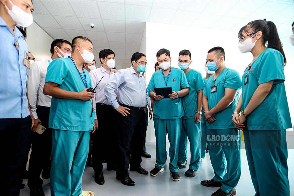 Thủ tướng cùng các y bác sĩ Bệnh viện Đại học Y Hà Nội  tại khu điều trị bệnh nhân nặng. Ảnh: Hải Nguyễn - Tô Thế