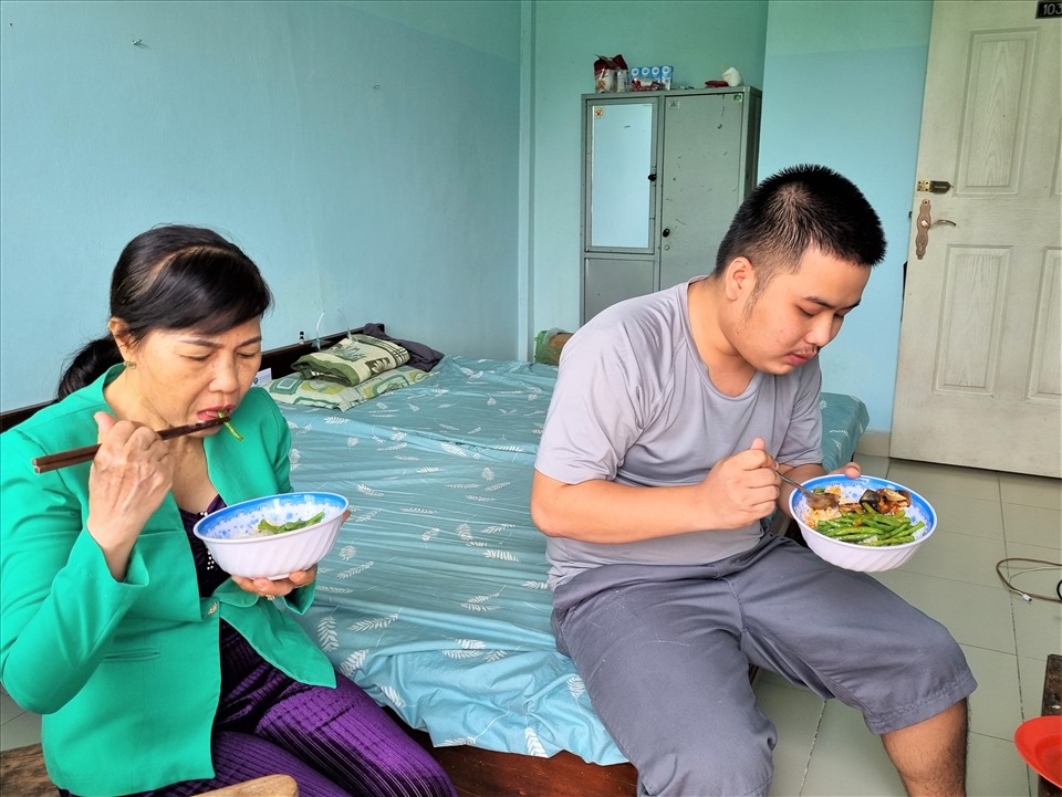 Chị Nguyễn Thị Bích Thu và con trai Nguyễn Tuấn Thanh, quê Quảng Ngãi, ở trọ trên đường Ung Văn Khiêm, được đưa vào lưu trú tại phòng 1036 đang ăn cơm trưa. Ảnh: Nam Dương
