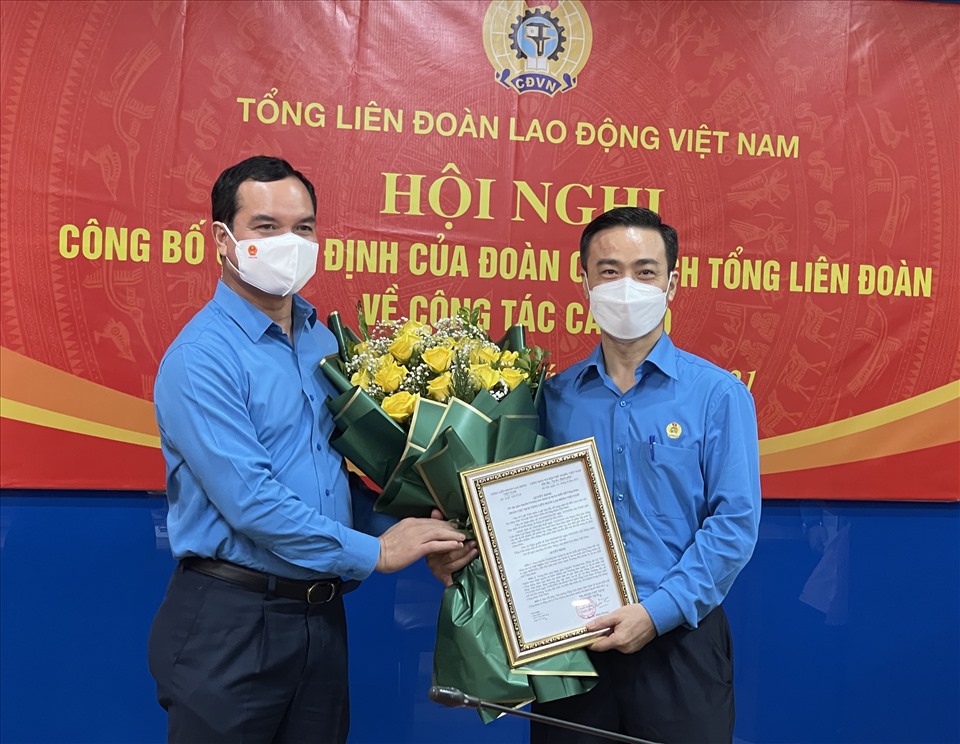 Chủ tịch Tổng LĐLĐVN Nguyễn Đình Khang trao quyết định và tặng hoa chúc mừng ông Lê Văn Nghĩa (bên phải ảnh). Ảnh: Việt Lâm