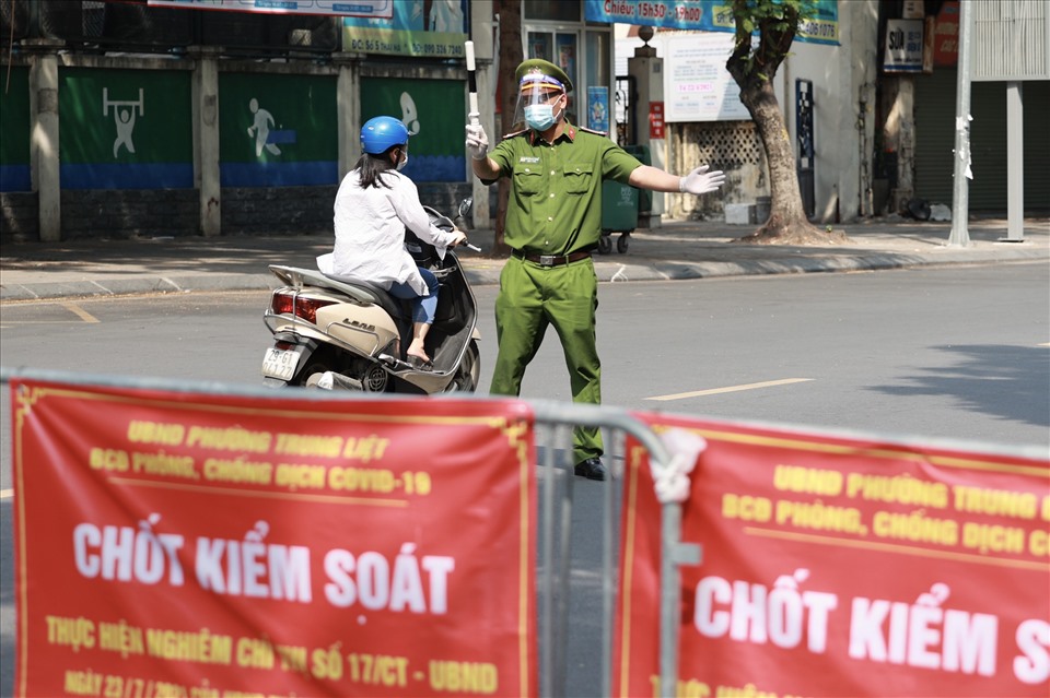 Giữa thời tiết oi bức ở Hà Nội trưa 6.8, các lực lượng chức năng phường Trung Liệt (Đống Đa) vẫn làm việc liên tục ở các chốt kiểm soát, kiểm tra giấy đi đường của người dân trong nội đô để phòng dịch COVID-19.