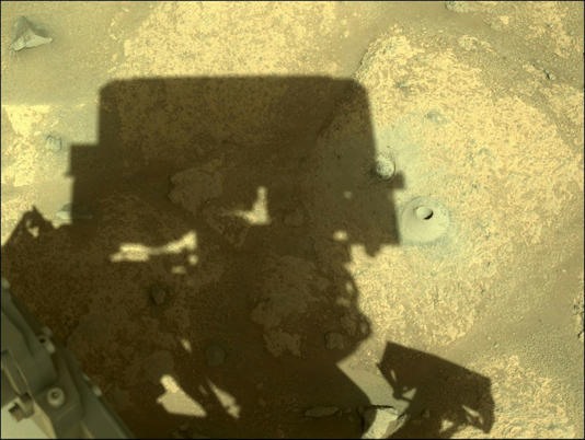 Bóng tàu thăm dò sao Hỏa của NASA cạnh mũi khoan đầu tiên. Ảnh: NASA