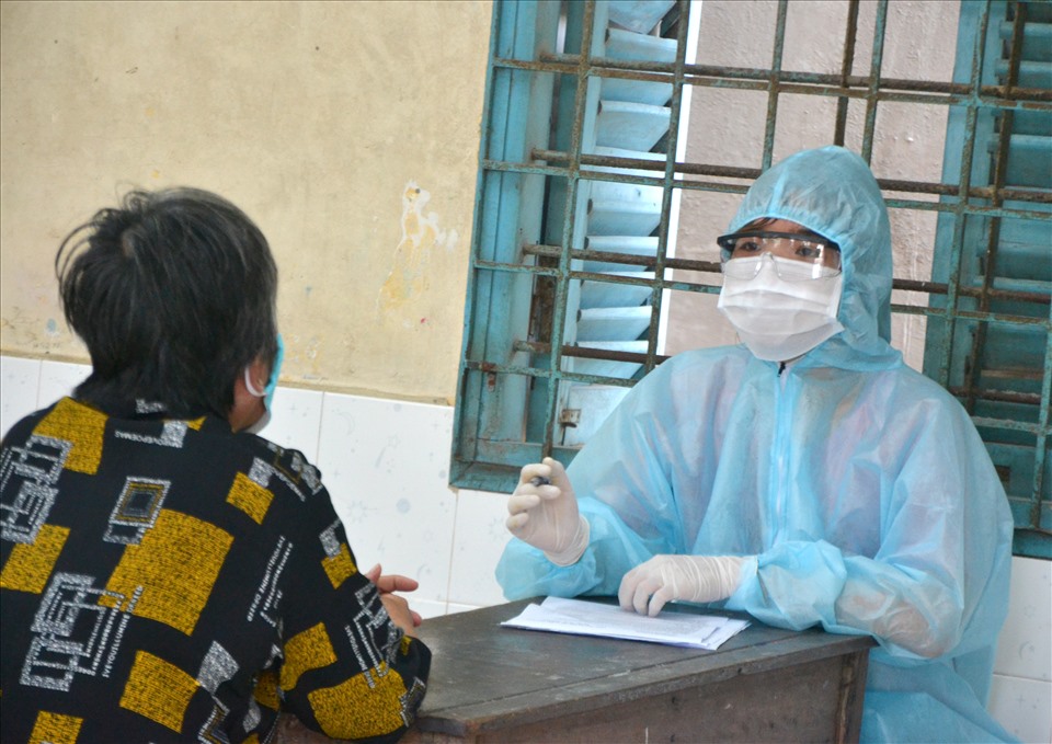 Nữ tân bác sĩ Nguyễn Phạm Cẩm Tú đang tư vấn cho cụ bà trước khi thực hiện tiêm vaccine COVID-19. Ảnh: LT
