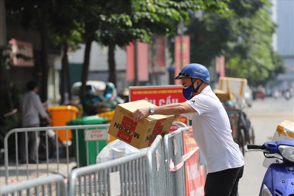 Tình nguyện viên mang thực phẩm cho người dân trong khu phong tỏa ở ổ dịch quận Thanh Xuân.