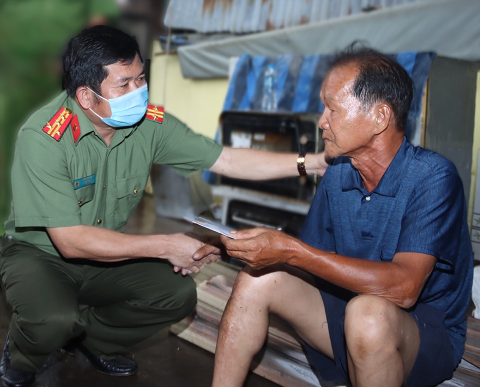Đại tá Đinh Văn Nơi trong lần thăm hỏi, chia sẻ và hỗ trợ người dân An Giang bị hỏa hoạn. Ảnh: CA An Giang