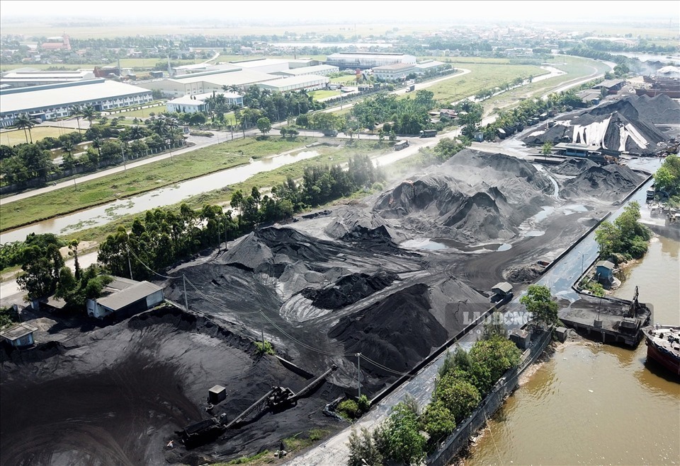 Các bãi tập kết than ngoài đe sông Đáy cũng là một trong những nguyên nhân dẫn đến tình trạng ô nhiễm môi trường tại KCN Khánh Phú và vùng giáp ranh. Ảnh: NT