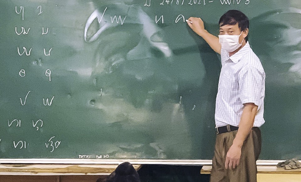 Anh Tòng Văn Hân trong một buổi dạy chữ Thái cổ.