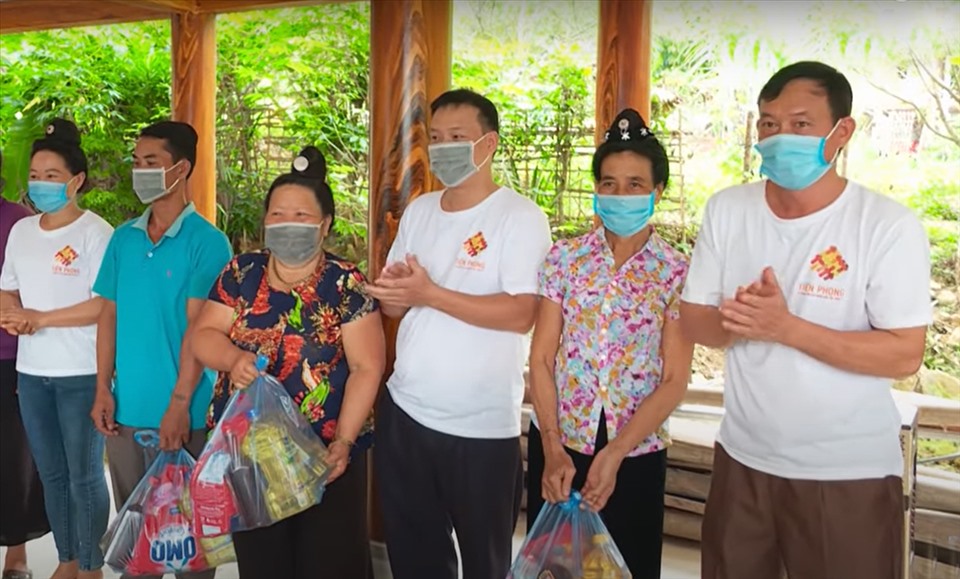 Anh Tòng Văn Hân (bên phải) cùng các thành viên nhóm Tiên Phong trao quà hỗ trợ người dân bị ảnh hưởng do COVID-19.