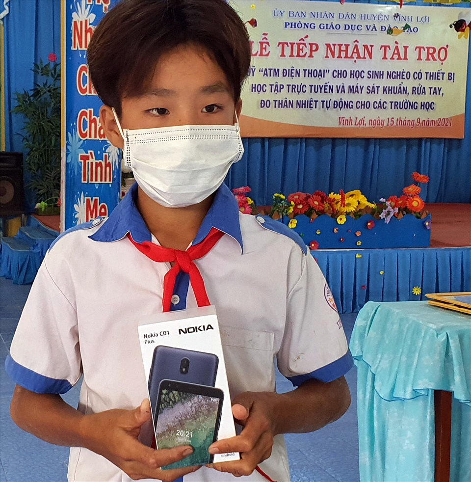 Lê Hoàng Em, nhận điện thoại từ chương trình ATM điện thoại cho em của huyện Vĩnh Lợi, tỉnh Bạc Liêu. Ảnh: Nhật Hồ